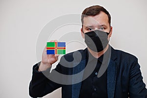 Man wear black formal and protect face mask, hold Lincolnshire flag card isolated on white background. United Kingdom counties of