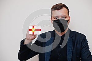 Man wear black formal and protect face mask, hold West Riding of Yorkshire flag card isolated on white background. United Kingdom