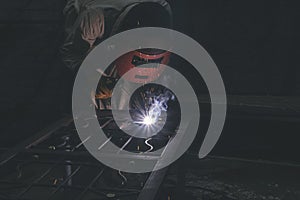 Man wear glove and goggles working with arc welding machine to weld steel at outdoor.