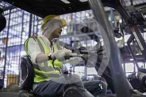 Man wear safety helmet driver forklift warehouse in factory. Male worker industrial operate. control loading container box.