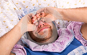 Man weared as baby in bed