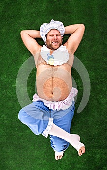 Man weared as baby on grass