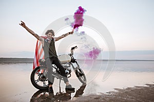 Man wearing american cape holding smoke bomb