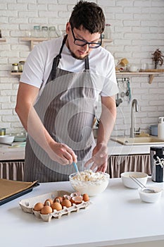 man wearing apron cooking tiramisu at kitchen