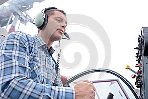 man wearing aviation headset by control panel