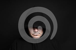 Man wearing black hoodie hiding eyes