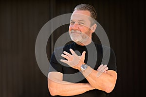 Man wearing a black T-shirt and showing his stylish watch