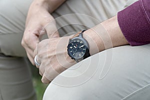 Man wearing black watch with brown leather strap