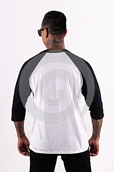 Man wearing black white raglan t-shirt 3/4 sleeve in back view with mockup concept