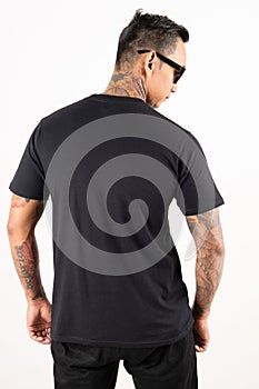 A man wearing blank plain t shirt isolated on white background. Hipster man with tattoo wearing black t shirt in back view.