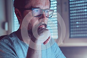 Man wearing blue light blocking prescription glasses while looking at computer screen