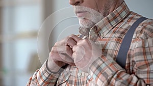 Man wearing checkered shirt and suspenders, old-fashioned clothes for job