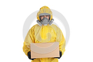 Man wearing chemical protective suit with cardboard box on background. Prevention of virus spread