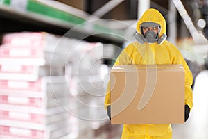 Man wearing chemical protective suit with cardboard box. Wholesale market