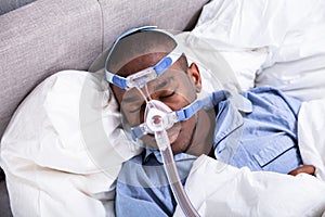 Man Wearing CPAP Mask Sleeping On Bed