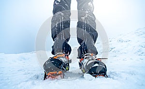 Man wearing crampons standing on snow