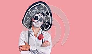 Man wearing day of the dead costume over background happy face smiling with crossed arms looking at the camera