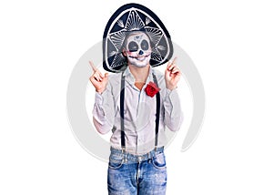 Man wearing day of the dead costume over background smiling confident pointing with fingers to different directions