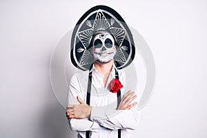 Man wearing day of the dead costume over white happy face smiling with crossed arms looking at the camera