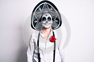 Man wearing day of the dead costume over white looking positive and happy standing and smiling with a confident smile showing