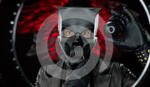 A man wearing a demon skull mask in a leather cloak