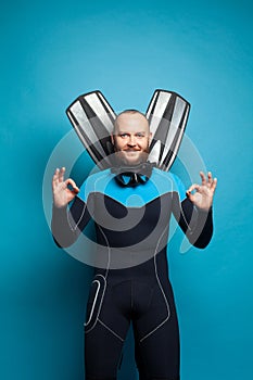 Man wearing diver suit doing swimming gesture, travel concept