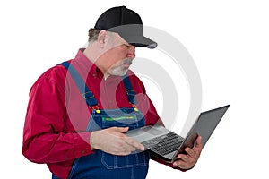 Man wearing dungarees holding laptop