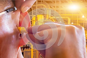 Man wearing ear plugs hearing protection for factory worker,safety concept