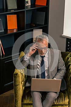 Man wearing eyeglasses sitting alone in the room