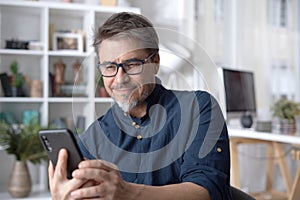 Man wearing eyewear, using phone at home, having video call