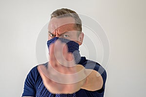 Man wearing a face guard holding up his hand photo