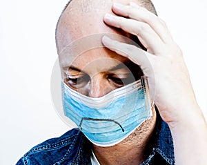 Man wearing a face mask looking down in despair or disbelief.