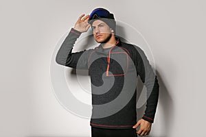 Man wearing fleece jacket and goggles on light grey background. Winter sport clothes