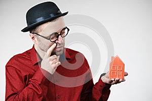 Man wearing funny eyeglasses holding house