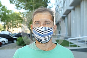 Man wearing handmade cloth mask outdoors. Personal protective equipment during COVID-19 pandemic