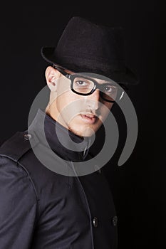 Man wearing hat, glasses and black coat