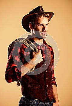 Man wearing hat hold rope. Ranch occupations. Lasso tool of American cowboy. Lasso is used in rodeos part competitive photo