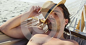 Man wearing hat lying in hammock