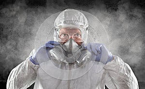 Man Wearing Hazmat Suit, Goggles and Gas Mask In Smokey Dark Room photo