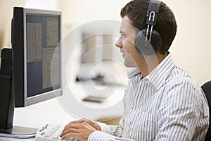 Man wearing headphones in computer room typing