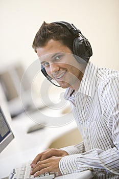 Man wearing headphones in computer room typing