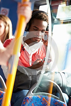 Man Wearing Headphones Listening To Music On Bus Journey