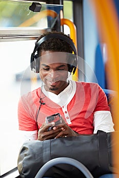 Man Wearing Headphones Listening To Music On Bus Journey