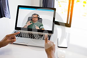 A man wearing headphones is using a laptop to communicate via video conferencing. Conversation during the coronavirus or COVID 19