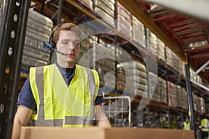 Man wearing a headset working in a distribution warehouse photo