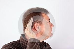Man wearing hearing aid cupping his hand behind ear