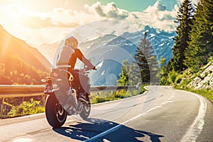 Man wearing a helmet and riding a motorcycle on a winding mountain road. The sun is shining, and there are trees and
