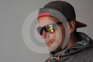 Man is wearing a hoodie and a bad sunglasses with scratch on lenses