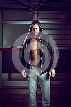 Man wearing hoodie posing in gym