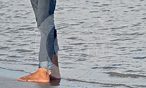 Man wearing jeans pant standing on a river bank area stock photograph
